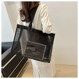 Gran bolso de malla negra transparente llevado al hombro para un estilo moderno.