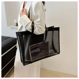 Bolso tote grande de malla negra para mujer que muestra estilo de carga y capacidad