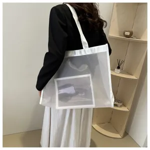 Vista trasera de un bolso tote de malla blanca transparente al hombro
