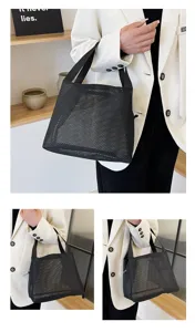 Lifestyle view of a black nylon mesh tote bag held by a model in a white blazer