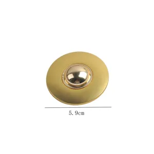 Detail view of 5.9cm golden round metal brooch with a reflective mirror finish