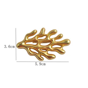 Detail view of matte gold coral brooch showing 5.9cm x 3.6cm dimensions