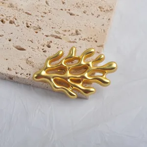 Detailed view of the matte gold coral-shaped brooch with organic branch textures