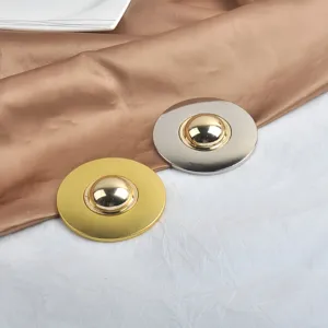 Detail macro view of minimalist round gold and silver metallic brooches with mirror finish
