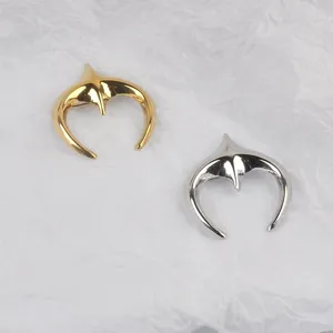 Detailed shot of star-moon stainless steel brooches in gold and silver finishes