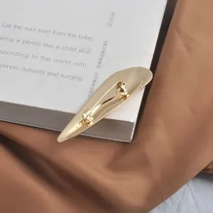 Détail de la face arrière d'une broche vague dorée polie avec fermeture de sécurité.