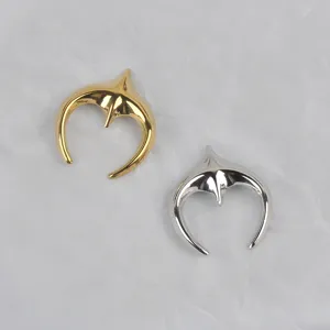 Detail view of polished stainless steel moon shape brooches in gold and silver finishes