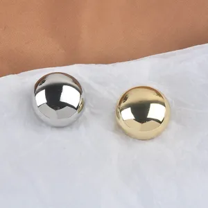 Macro detail of gold and silver metallic dome brooches with mirror finish texture