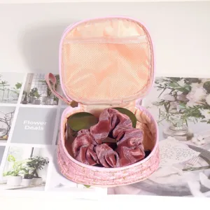 Vue détaillée d'une trousse de rangement en tweed rose montrant l'intérieur et la poche filet.