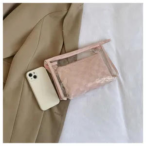 Detail shot of two-piece PVC travel cosmetic bag set featuring pink checkered inner pouch