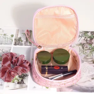 Vue détaillée de la trousse à maquillage en tweed rose montrant le rangement intérieur