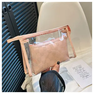 Close-up showing the pink checkered inner pouch of a clear PVC travel cosmetic bag set.