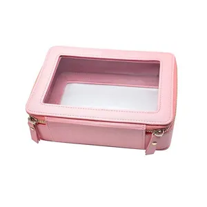 Nahaufnahme einer rosa PU-Kosmetiktasche mit transparentem Fenster und goldenen Reißverschlüssen