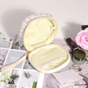 Gros plan d'une trousse à maquillage en tweed blanc avec poche filet intérieure