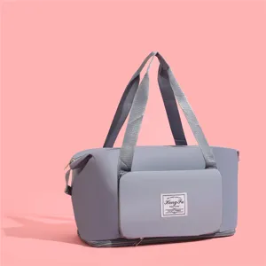 Grand sac de voyage gris imperméable avec poche avant sur fond rose