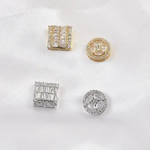 Close-up of four sparkling cubic zirconia magnetic brooches in gold and silver tones.
