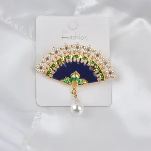 Detailed view of a Chinese style fan brooch featuring blue enamel and a teardrop pearl