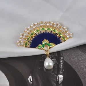 Detailed macro view of a Chinese style fan brooch with blue enamel, gold accents and pearls.