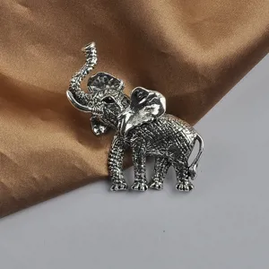 Gedetailleerde close-up van de complexe textuur van deze vintage zilveren olifant broche speld