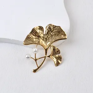 Detaillierte Nahaufnahme einer goldenen Ginkgoblatt-Brosche mit Perlenakzenten