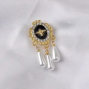 Nahaufnahme einer Vintage Gold Biene Brosche mit Strasssteinen und Perlenanhängern