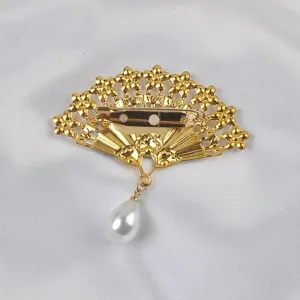 Detail view of the safety pin closure on the back of the golden fan-shaped brooch.