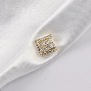 Close-up detail of a square gold-tone magnetic brooch inlaid with sparkling rhinestones
