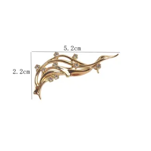 Gros plan d'une élégante broche vague dorée avec strass, taille 5,2 cm x 2,2 cm.
