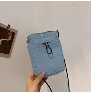 Detalle macro de un bolso pequeño de lona azul claro para móvil con cordón ajustable