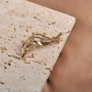 Vue rapprochée montrant les strass étincelants sur une broche artistique en forme de vague