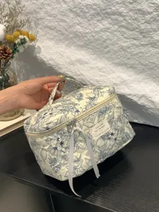 Portable floral quilted cotton makeup bag with a sturdy handle and large storage capacity