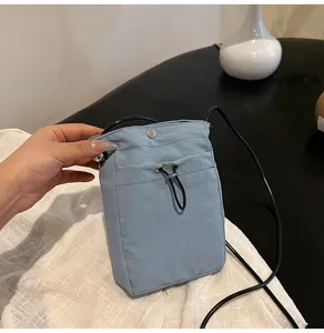 Bolso bandolera minimalista de lona azul claro para móvil con detalle de cordón