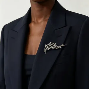 Gros plan sur une broche artistique en forme de vague avec des diamants