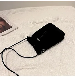 Vista detallada del mini bolso negro de lona con cordón para móvil