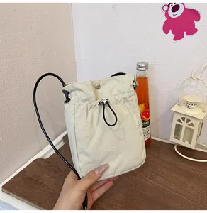 Detalle de mini bolso de lona crema para móvil con cordón ajustable