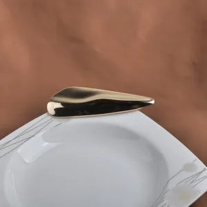 Vue détaillée d'une broche moderne en métal doré avec une finition miroir polie