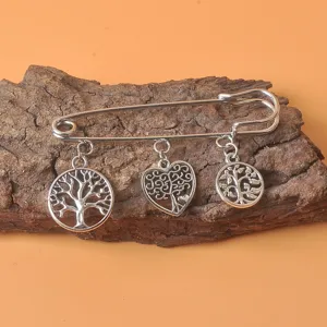 Detailansicht der Vintage-Brosche in Silber mit Lebensbaum- und Herzanhängern.