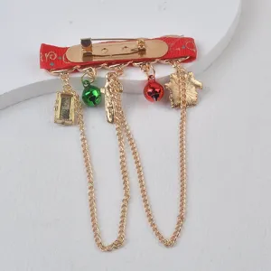 Detail view of a festive Christmas brooch back featuring red ribbon and gold chains