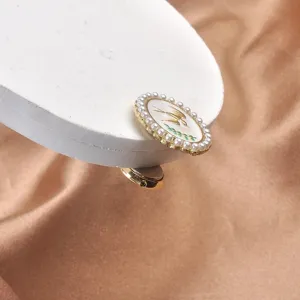 Primer plano detallado de elegante broche magnético con pájaro y perlas sobre satén
