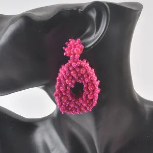 Dettaglio di orecchini a perno in perline rosa fatti a mano su manichino
