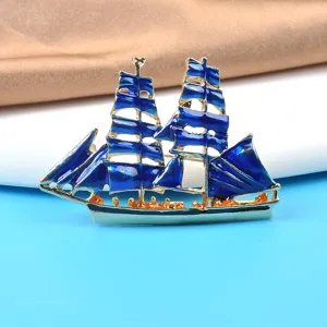 Close-up detail of a vintage navy style enamel sailing ship brooch with deep blue sails