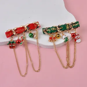 Close-up detail of Christmas brooches featuring festive ribbons, charms, and gold chains