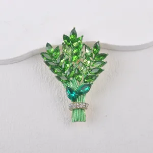 Makro-Detail einer eleganten grünen Kristall-Blumenstrauß-Brosche mit Strasssteinen