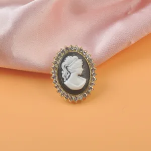 Primer plano de broche magnético de camafeo vintage con pedrería y marco de color oro