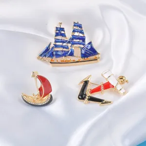 Retro nautical enamel brooches featuring sailboat and anchor designs on white silk background