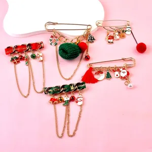 Detailed view of festive Christmas brooch set with Santa Claus and tree charms on pink base