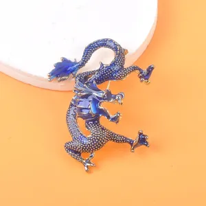 Nahaufnahme der eleganten blau-goldenen Drachenbrosche mit strukturierten Schuppen
