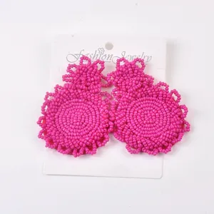 Primo piano dettagliato di orecchini fatti a mano con perline di riso intrecciate rosa