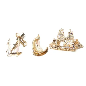 Vintage gold marine style brooch set with anchor and sailboat designs for suits.