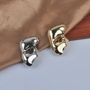 Close-up of vintage-style phantom mask brooches in shiny gold and silver finishes